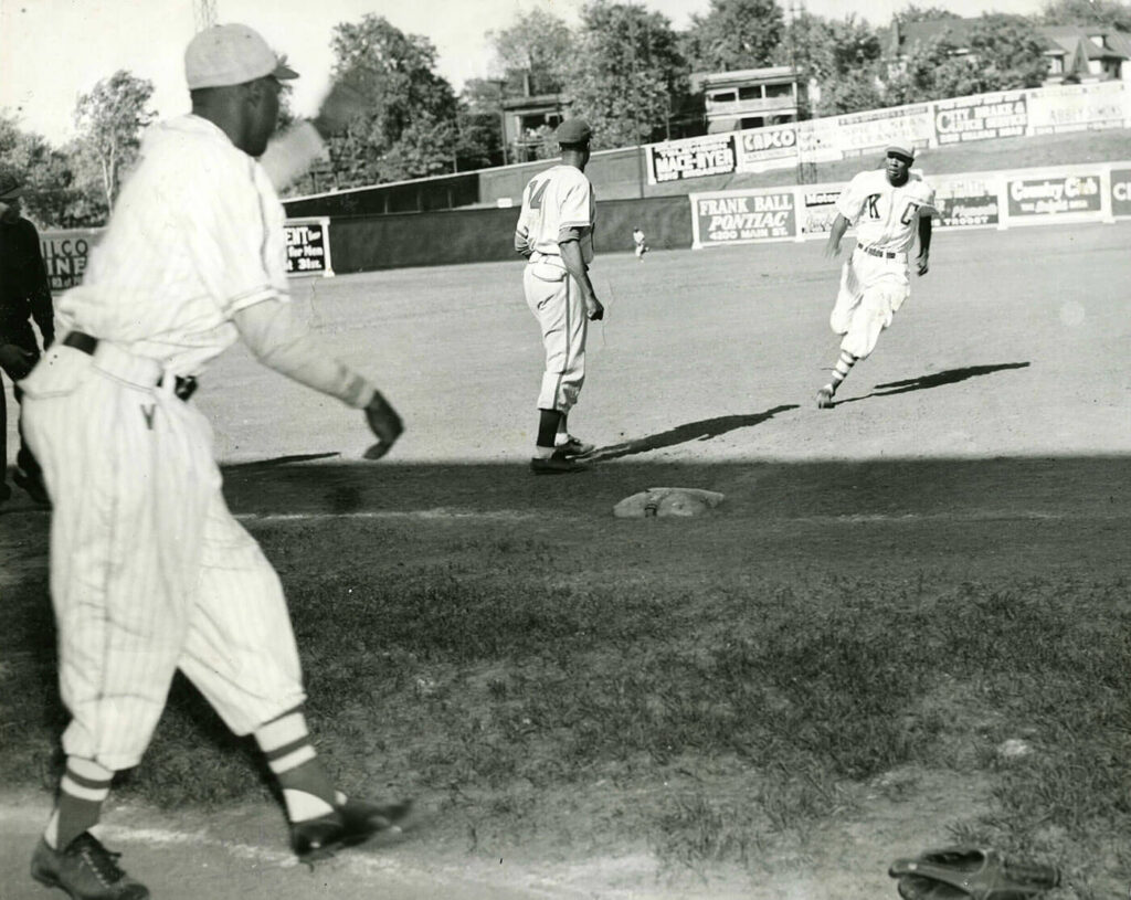 Black and white photo of Buck O'Neil rounding third with the KC Monarchs