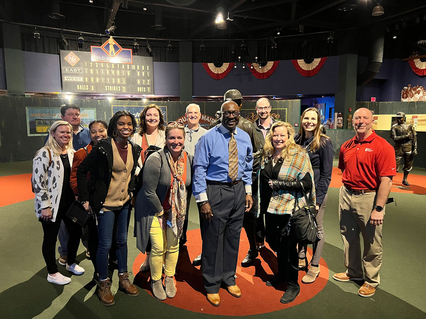 group of people standing for a photo in the exhibit room. 