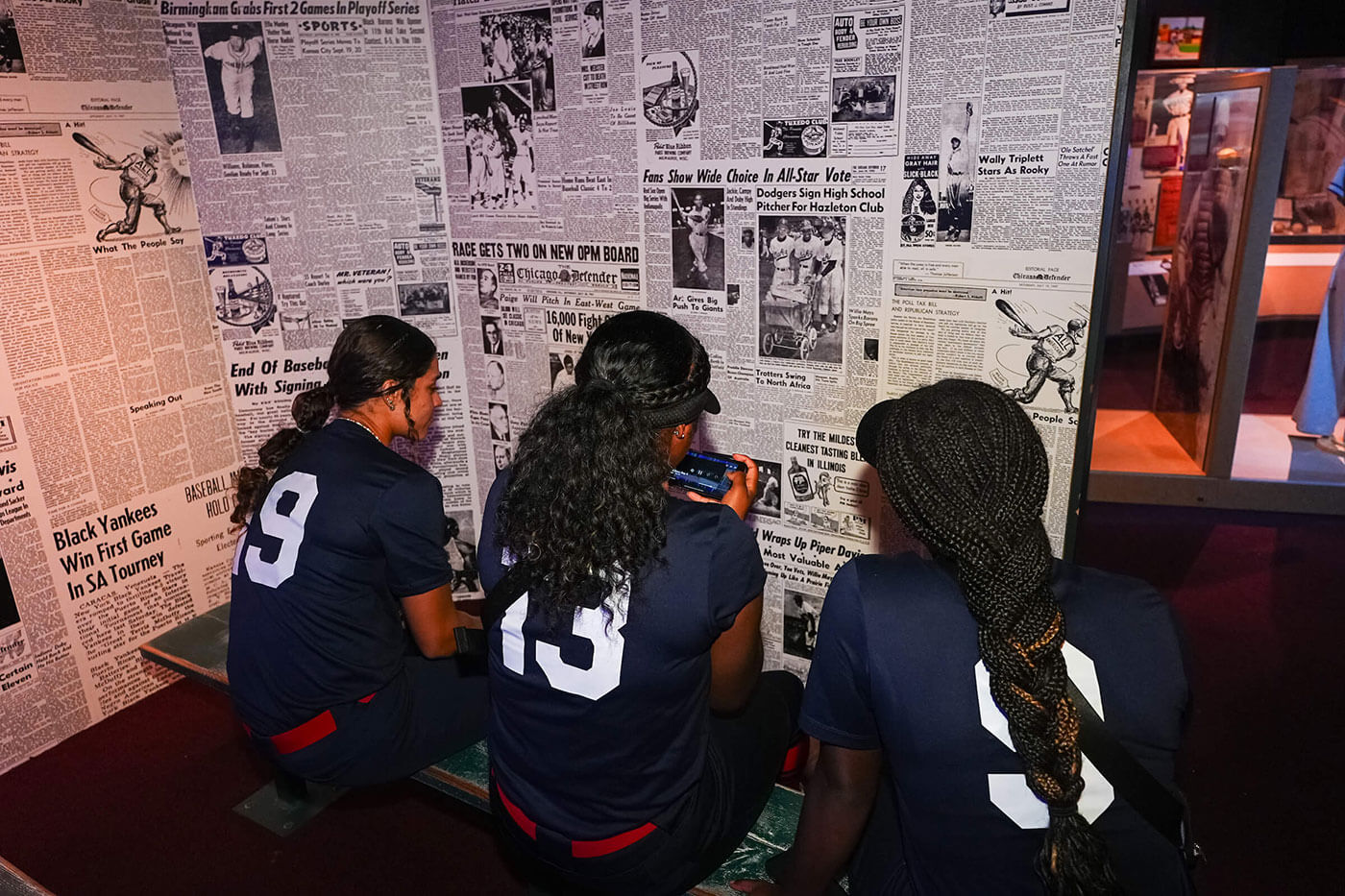 A group of young girls on a team looking at an exhibit