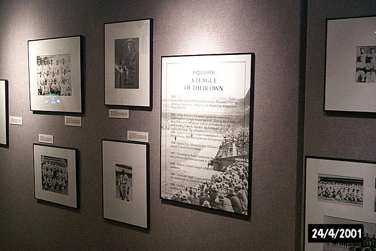 framed images and info cards on a wall for the Discover Greatness exhibit