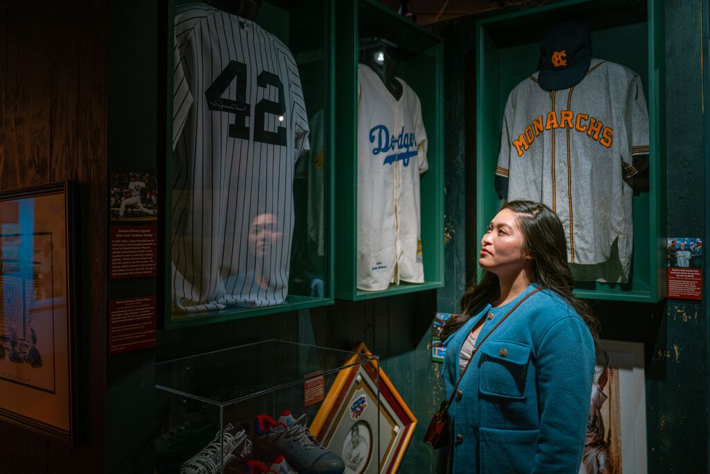 Woman looking at the historical jerseys at the NLBM