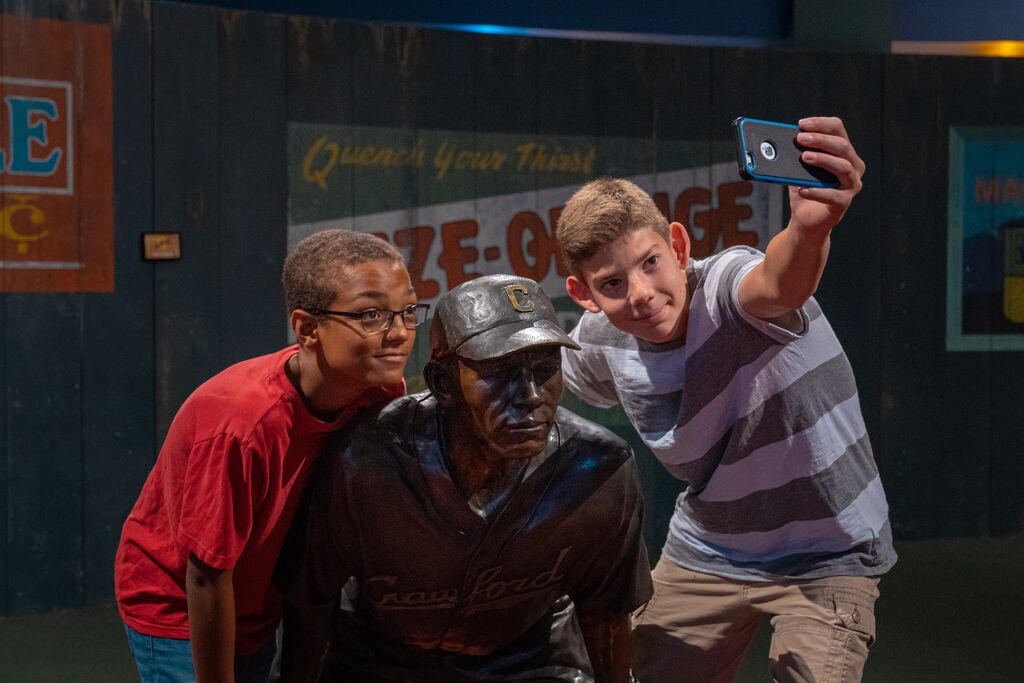 Two boys taking a picture with one of the life-size statues at NLBM